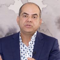 Man in suit discussing a topic.